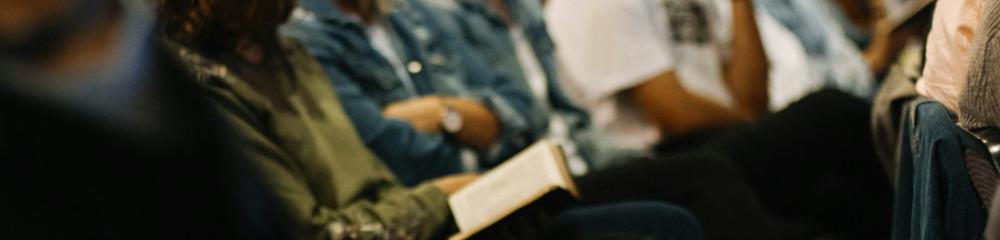 People seated in a meeting with notebooks on their lap, eager to write