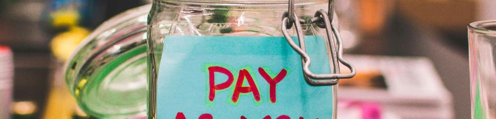 Coin-collecting jar with "Pay As You Wish" label
